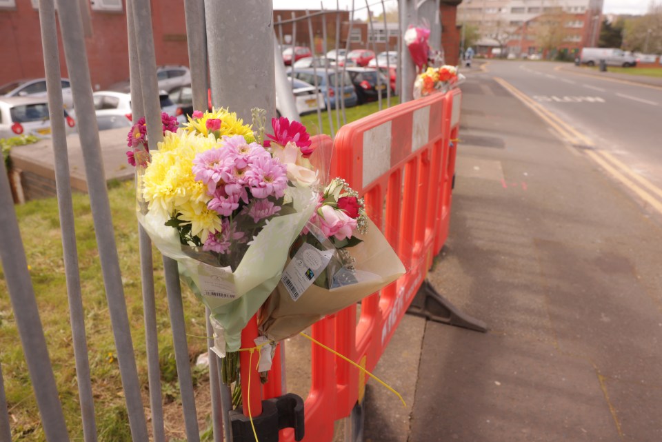 Flowers tied to a fence at a roadside memorial.