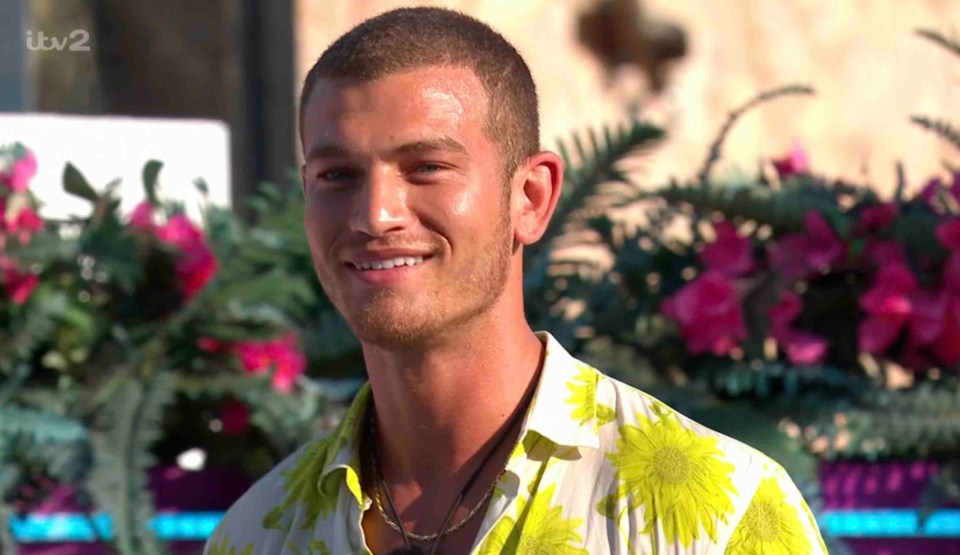 A man in a floral shirt smiles.
