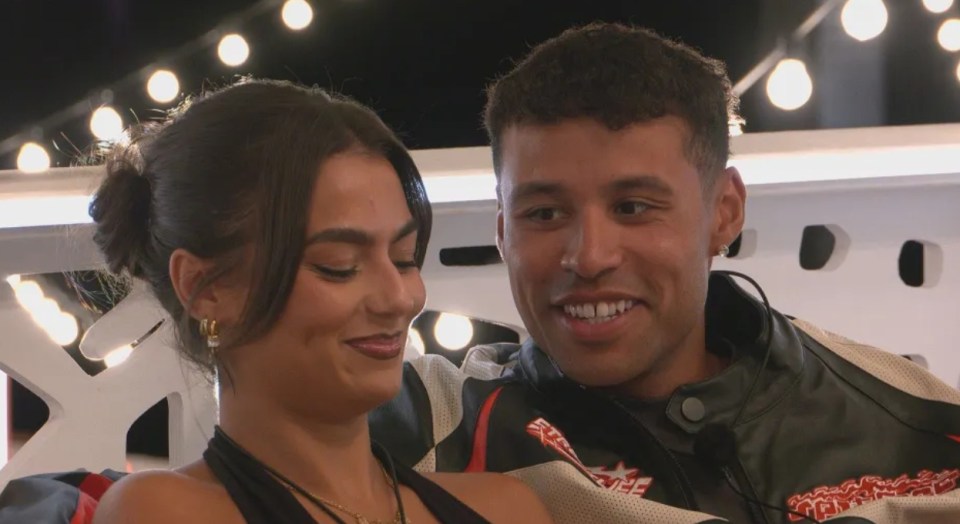 Screenshot of a young couple smiling at each other.