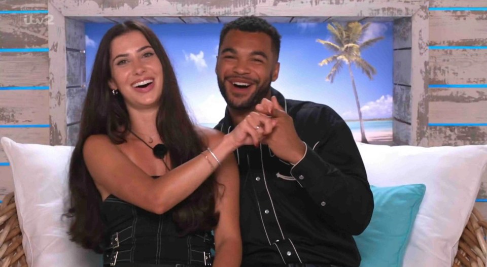 Yasmin and Jamie from Love Island holding hands and laughing.
