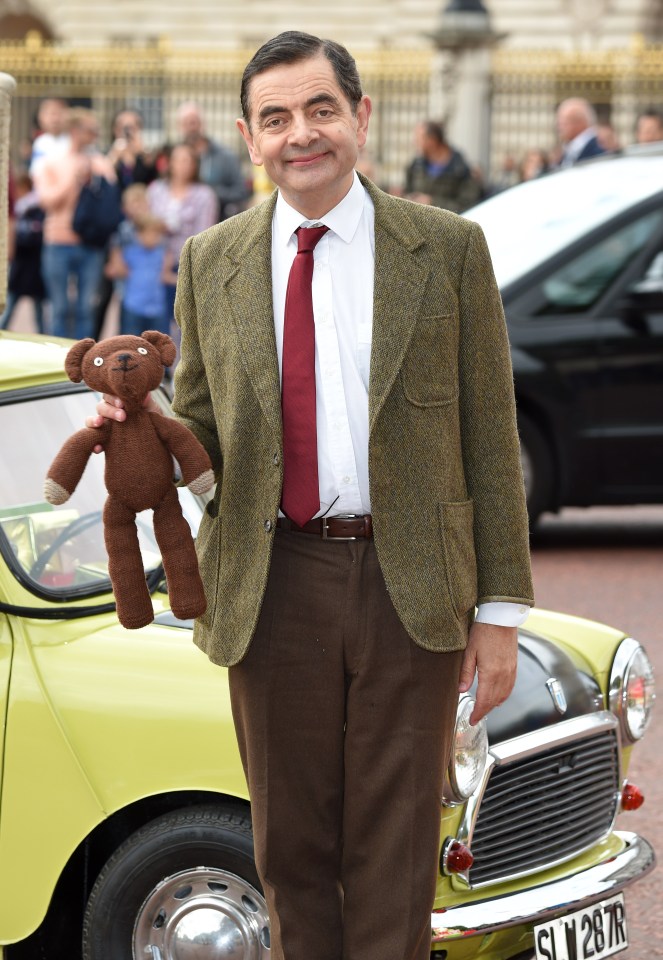 Rowan Atkinson as Mr. Bean at Buckingham Palace, holding Teddy.