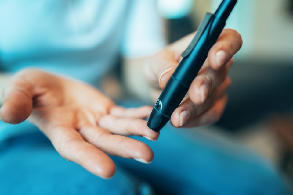 Woman pricking finger to test blood sugar.