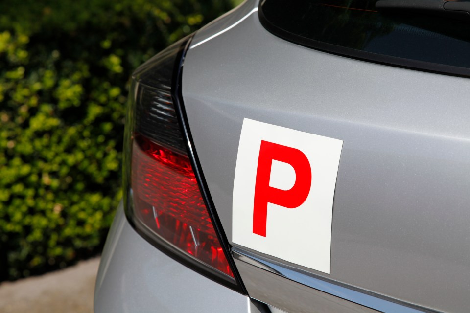 A silver car with a red "P" plate.