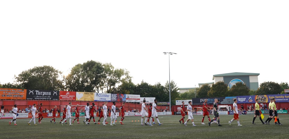 Tamworth and Manchester United U21 players walking onto the field.
