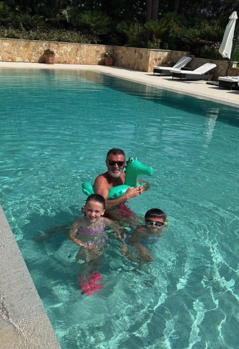 Roy Keane in a swimming pool with two children and a crocodile float.