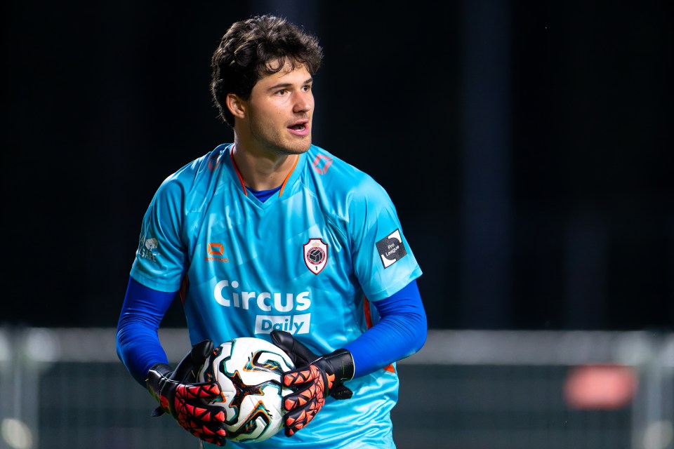 Senne Lammens of Royal Antwerp FC holding a soccer ball.