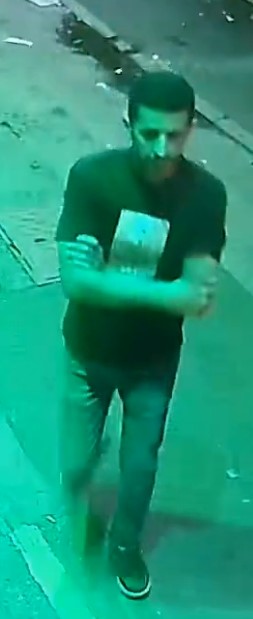 Surveillance image of a man in a dark shirt and pants.