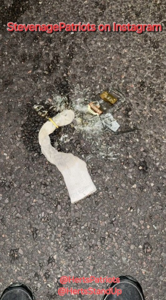 Broken bottle and sock on the ground.