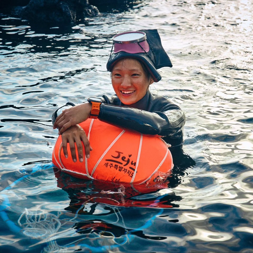 Haenyo woman in Jeju, South Korea, resting with a floatation device after freediving.