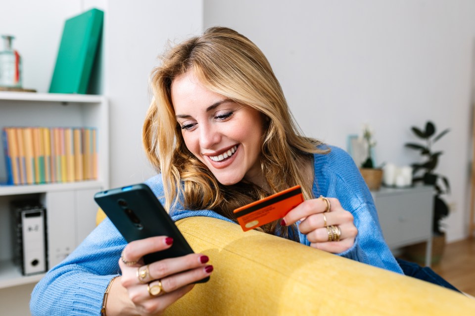 Woman smiling while online shopping on her phone.