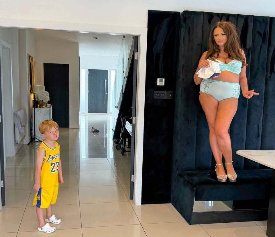Woman in lingerie in kitchen, caught by her young son.