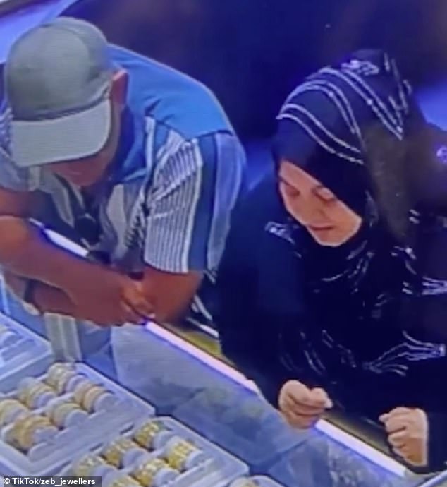 CCTV shows the pair, believed to be Romanian nationals, during the distraction theft where the woman leaned over the counter to obscure the owner's view while the man took the bracekets