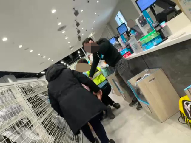 A Primark employee and customer fighting in a store, security guards intervening.