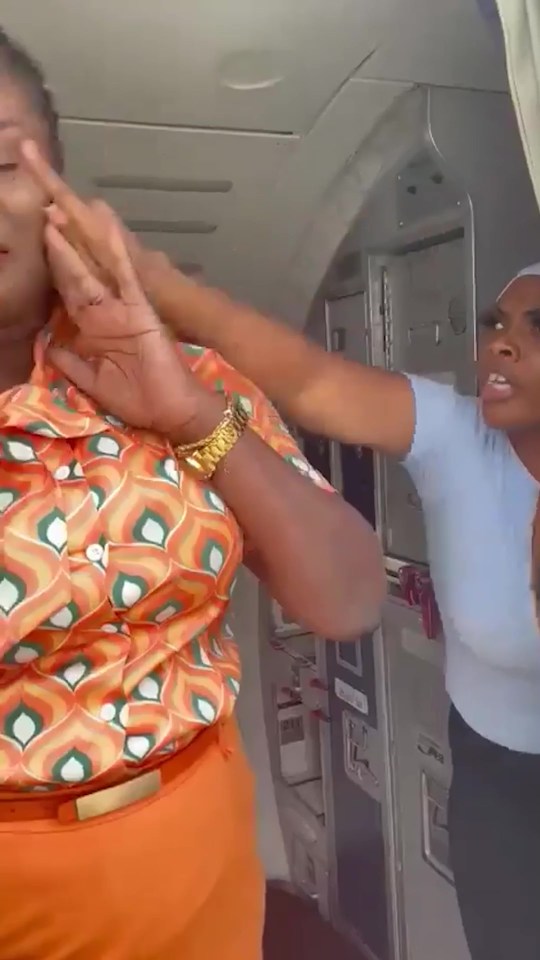 A flight attendant being assaulted by a passenger.