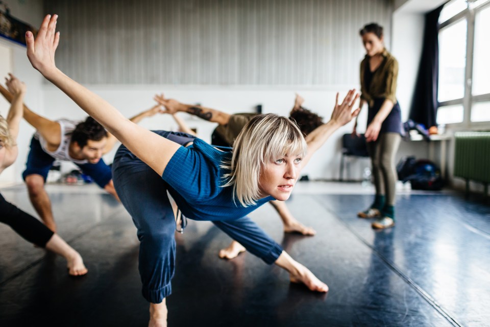Young adult dancers rehearsing in a studio.