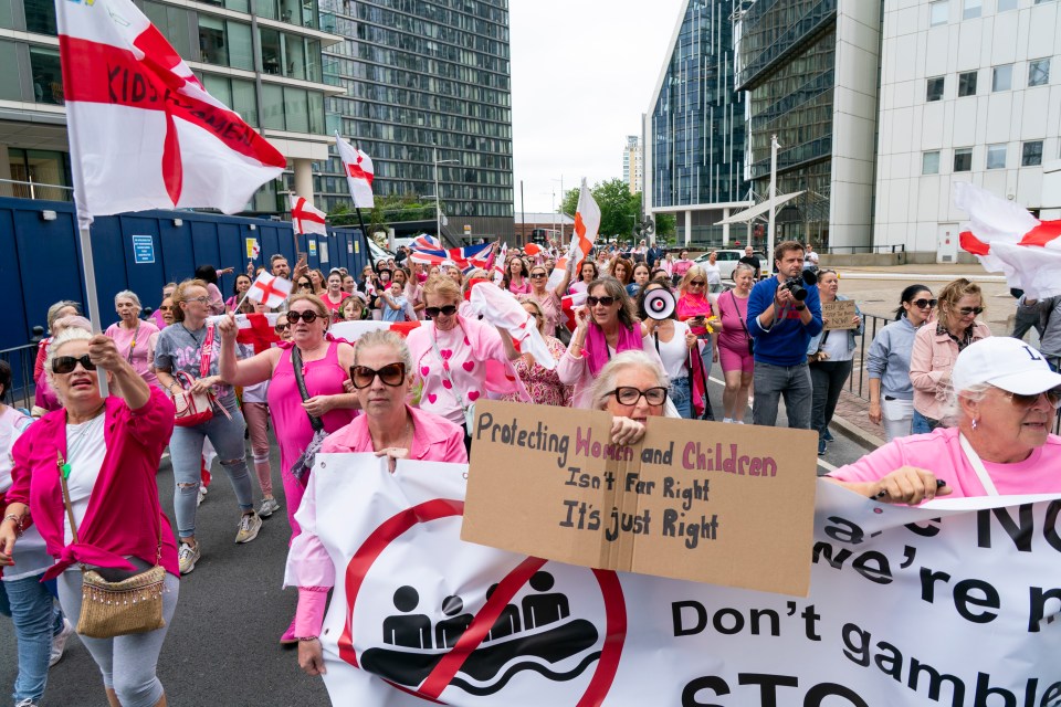 Protestors marching with signs against immigration.