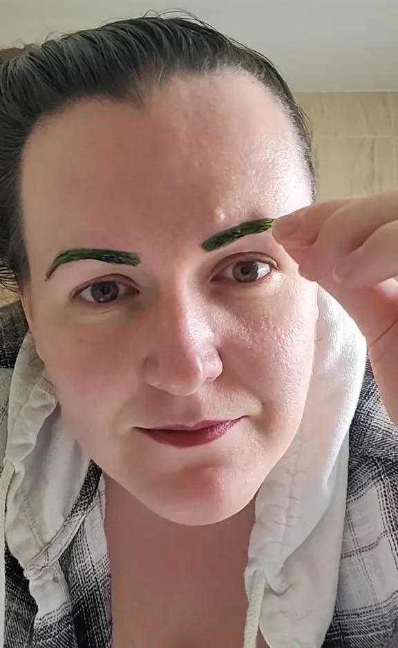 Person with green eyebrows after at-home dye job.