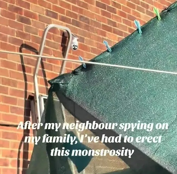 Security camera and shade cloth installed to deter spying neighbor.