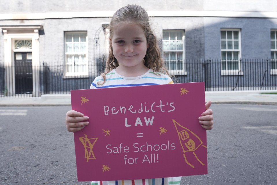 Girl holding sign advocating for Benedict's Law for safer schools.