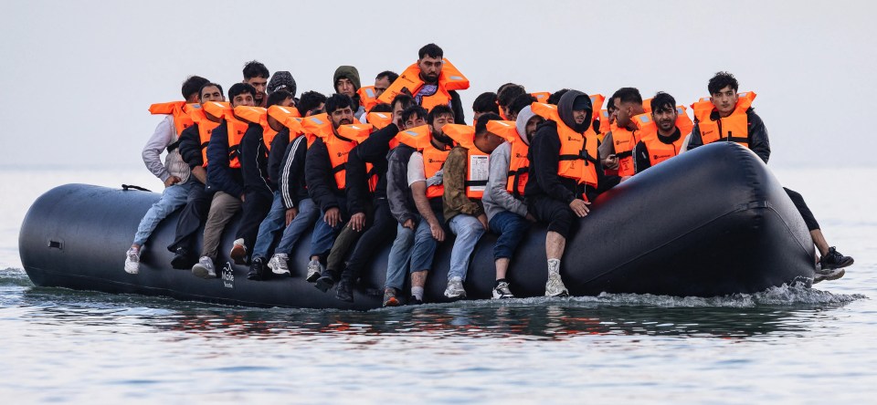 Migrants in a small boat on the water.