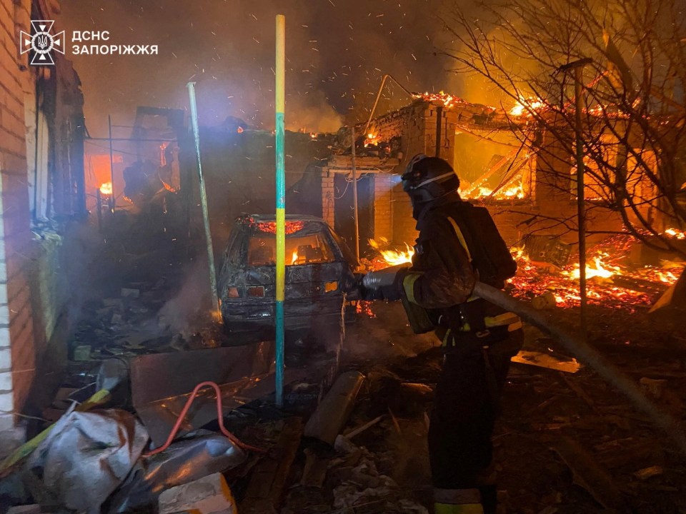 Firefighter battling a fire at a damaged apartment building.