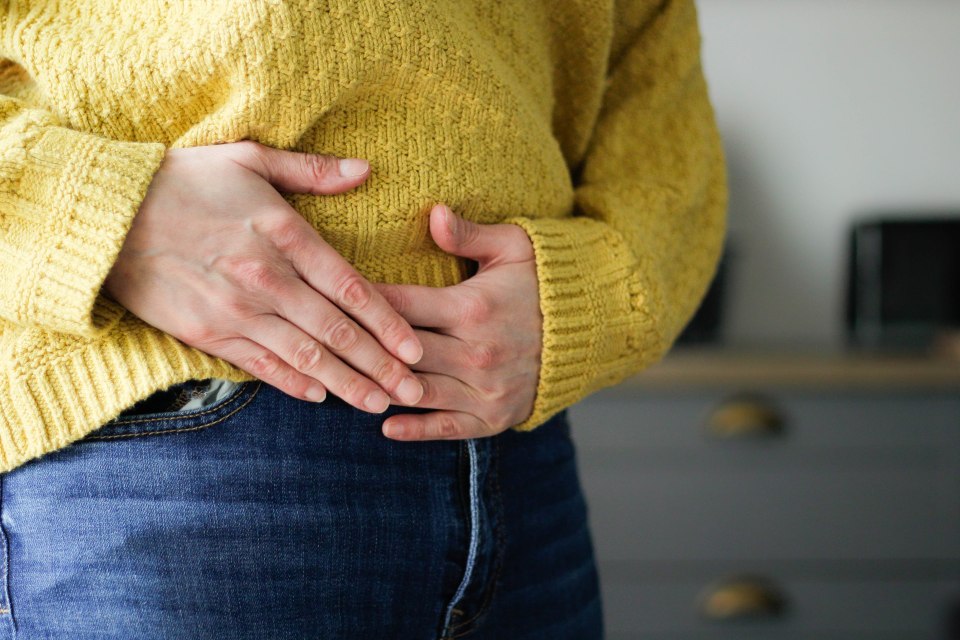 Person holding their stomach.