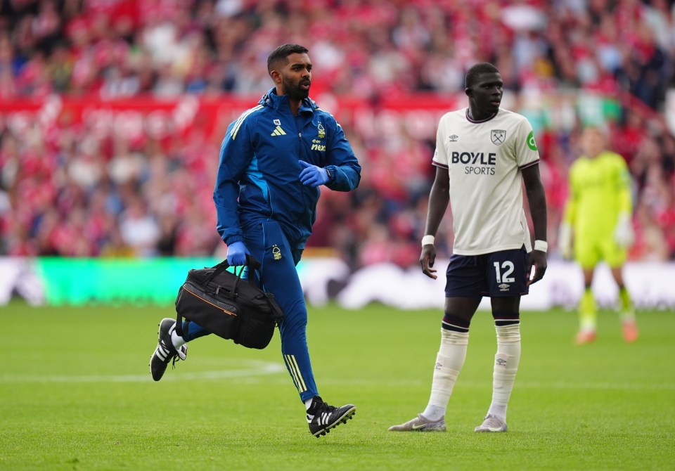 Nottingham Forest medical staff member running onto the pitch during a match.