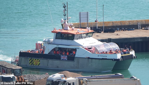 A group of people thought to be migrants are brought in to the Border Force compound in Dover, Kent