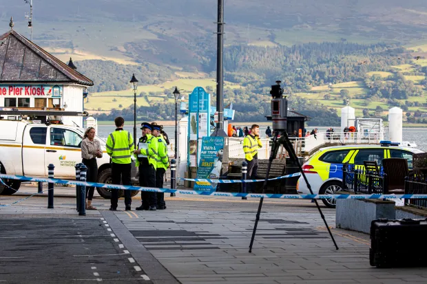 a police car is parked in front of a sign that says the pier kiosk