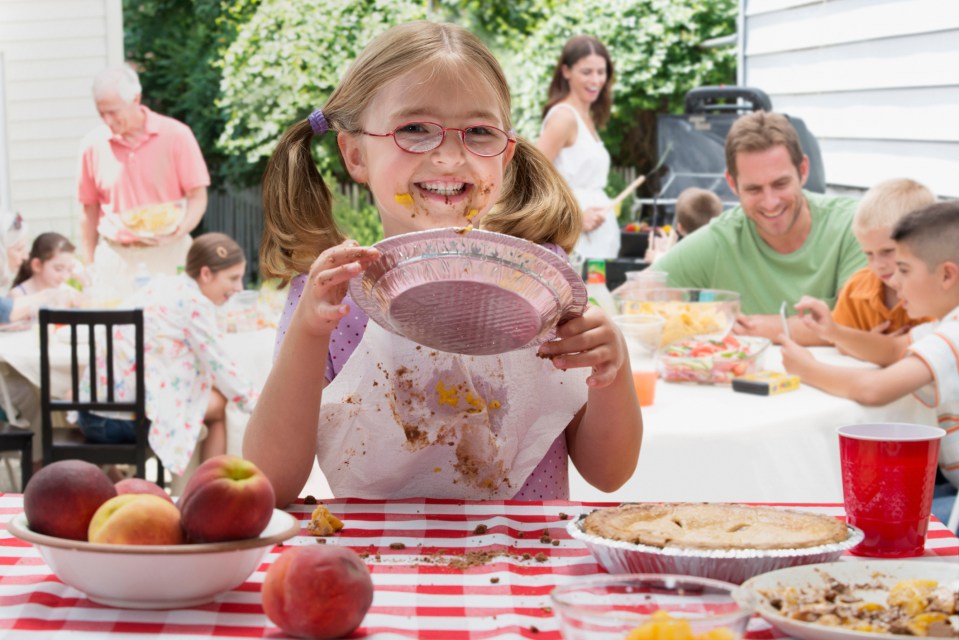 Girl covered in pie at a family picnic.