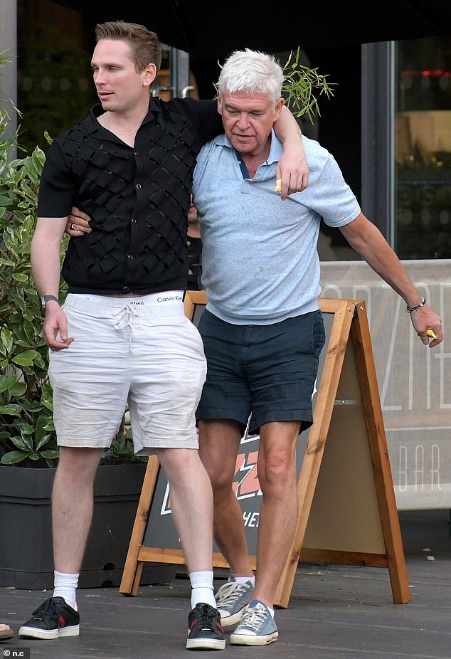 Worse-for-wear Phillip Schofield got cosy with a bleary-eyed male pal on Saturday - while his ex-friend Holly Willoughby was enjoying a wholesome time in Portugal