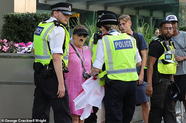 'Pink Lady' anti-migrant protesters have clashed with police outside a hotel housing asylum seekers in Canary Wharf today in the latest wave of demonstrations