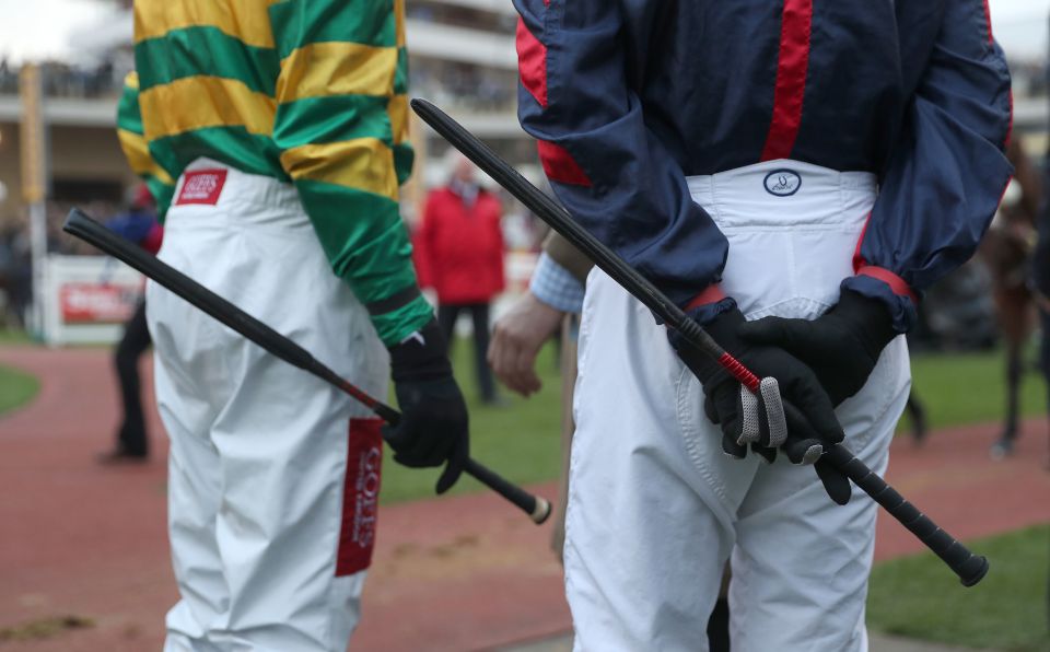 Jockeys holding riding crops.