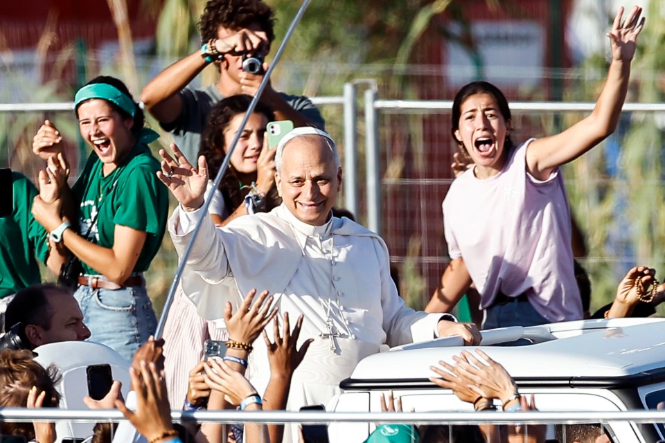 Pope Leo XIV waving from a popemobile to young people at a Jubilee of Youth Mass.