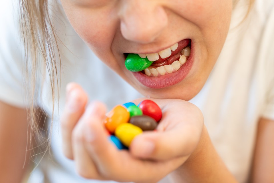 Girl eating colorful candies.