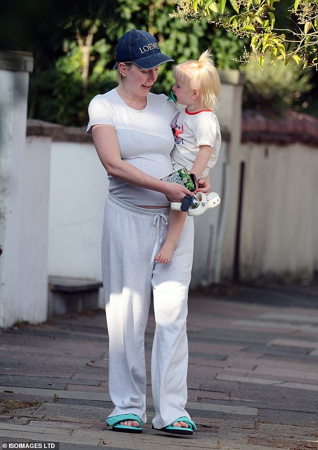 Carrying Fenna on her hip, she dressed casually in a plain T-shirt which she teamed with a pair of matching jersey bottoms