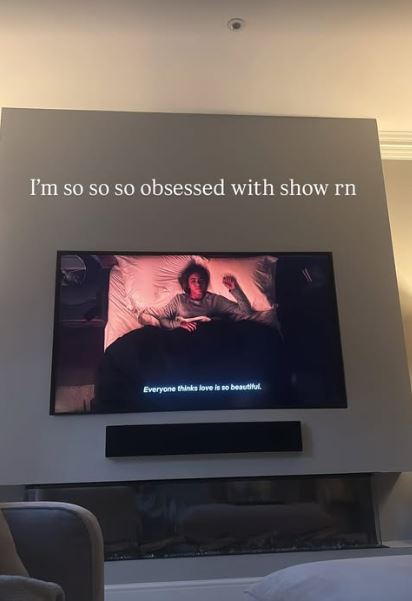 Photo of a TV screen showing a scene from a show, with the caption "I'm so so so obsessed with show rn" above it.