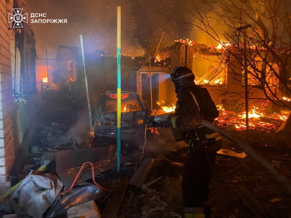 Firefighter battling a blaze at a burning building.