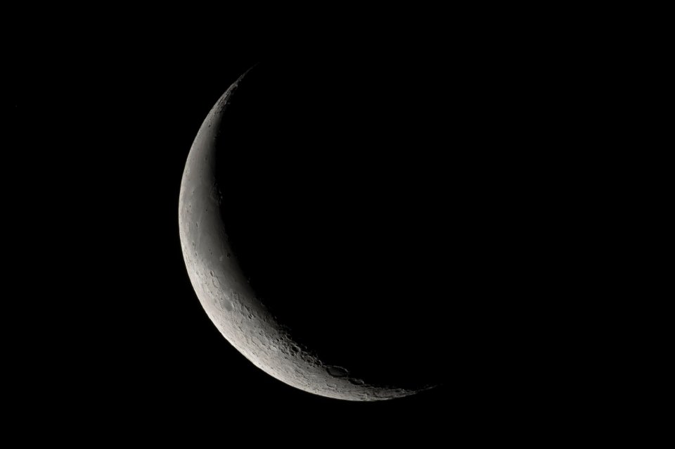 Waning crescent moon in a dark sky.