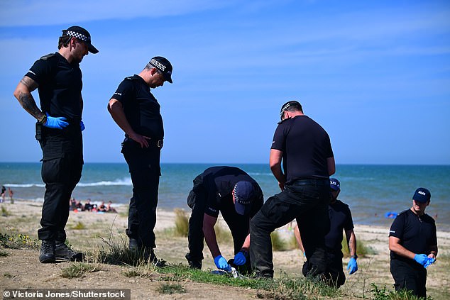 Police pictured searching the scene near Warden Bay beach on the Isle of Sheppey on August 11