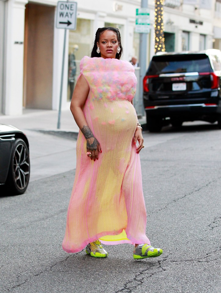 Rihanna walking in Los Angeles wearing a pink dress and Puma sneakers.