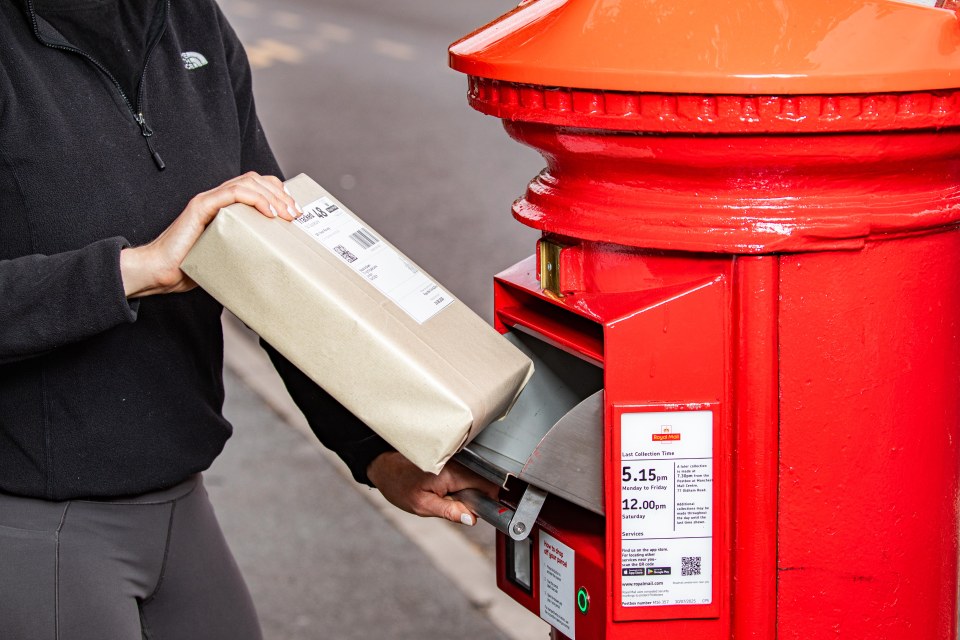 Person posting a package into a Royal Mail postbox.