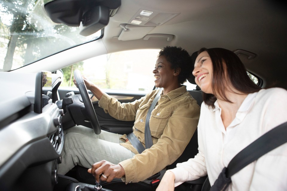 Two women laughing in a car.