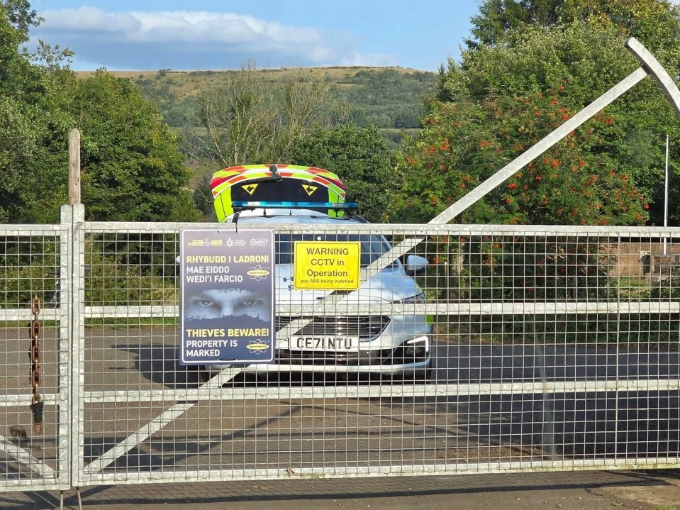 Police car outside a gate at a scout camp.