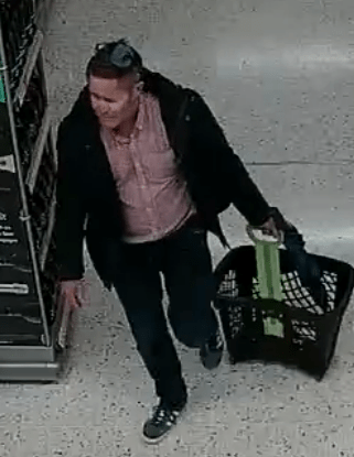 Surveillance image of a man carrying a shopping basket.