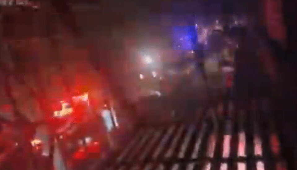 Blurry image of a dark scene with red and blue lights.