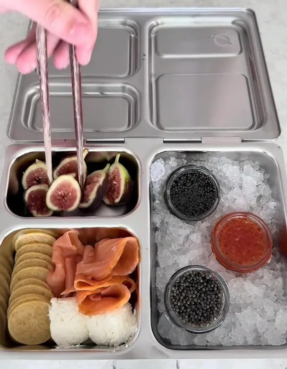 Luxury packed lunch with caviar, salmon, and figs.