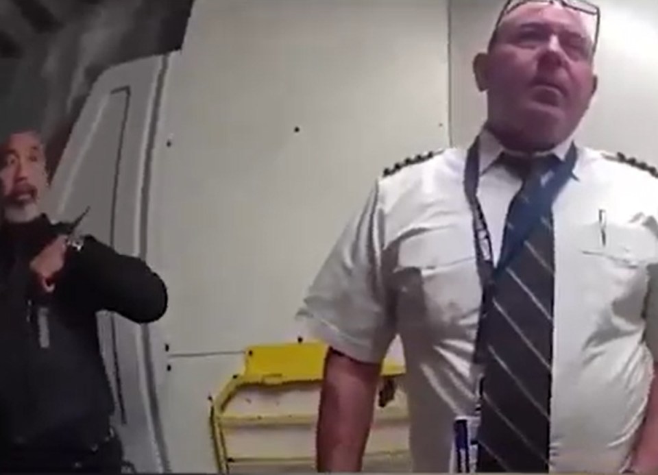 Police officer escorting a pilot from a cockpit.