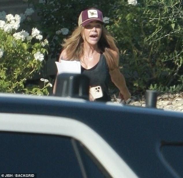 Dramatic photos show the moment Denise Richards was confronted by police officers during her visit to ex Aaron Phyper's Calabasas home on Sunday, just days after she took out a temporary restraining order on him