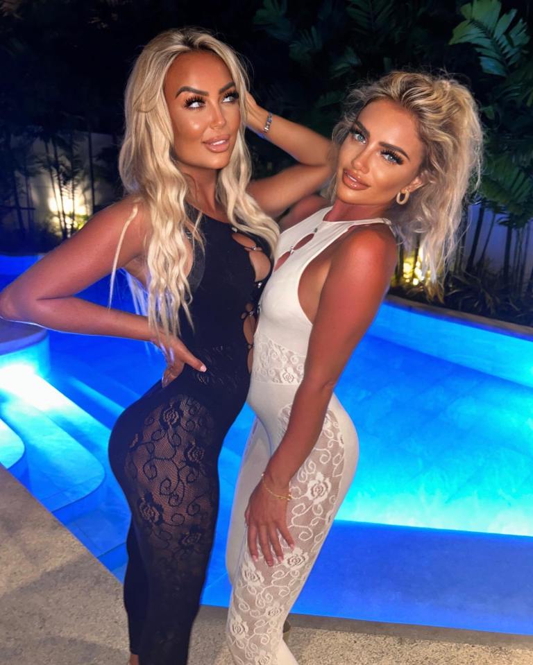 Two women in lace jumpsuits by a pool.